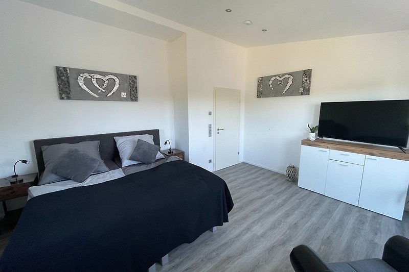 Schlafzimmer, elektrisches Boxspringbett, Leseecke, Fernseher.