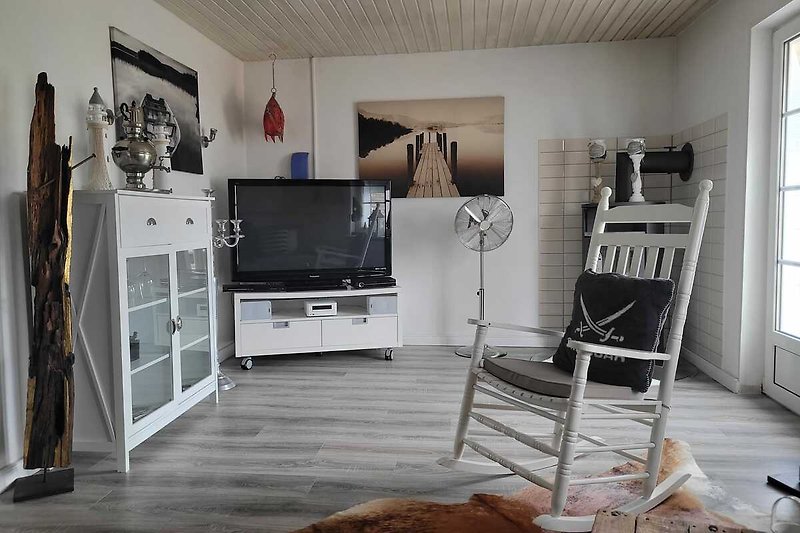 Wohnzimmer mit Fernseher, Couch und Holzmöbeln.