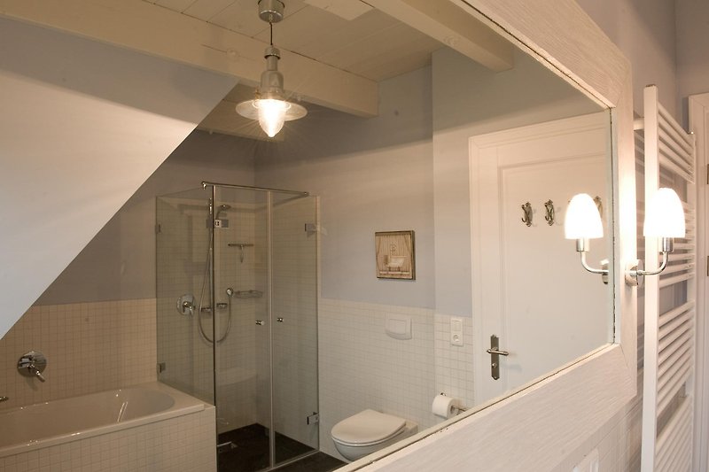 Schönes Badezimmer mit  Spiegel, Badewanne und Dusche und Doppelwaschtisch.