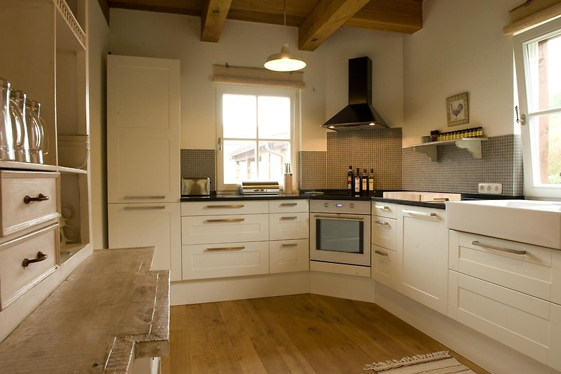 Vollausgestattete Küche mit stilvoller Einrichtung und Holzboden.
