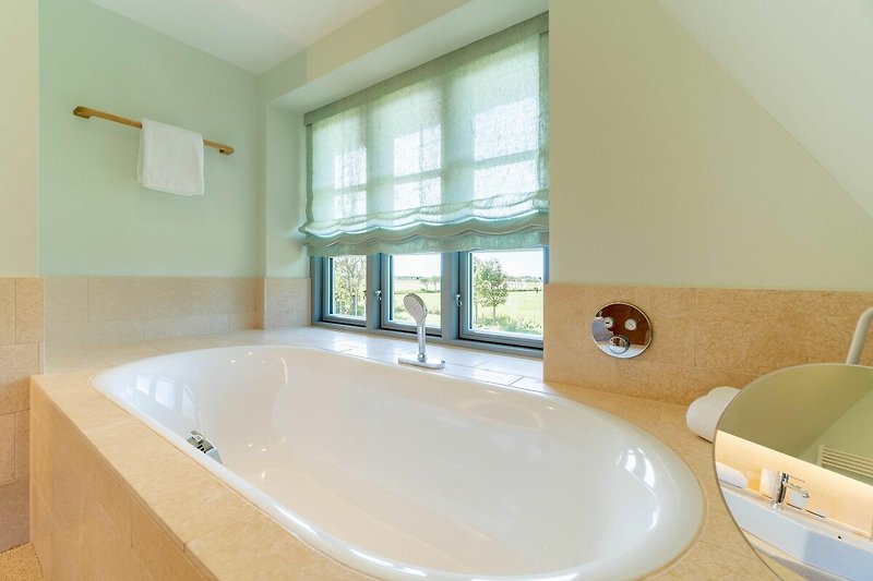 Die Badewanne befindet sich auf einem Podest, sodass Sie bei einem entspannten Bad einen herrlichen Ausblick haben.