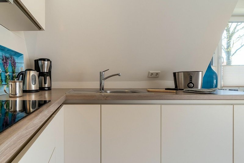 Die Küchenzeile ist unter anderem mit einer Filterkaffeemaschine, einem Toaster und einem Wasserkocher ausgestattet.