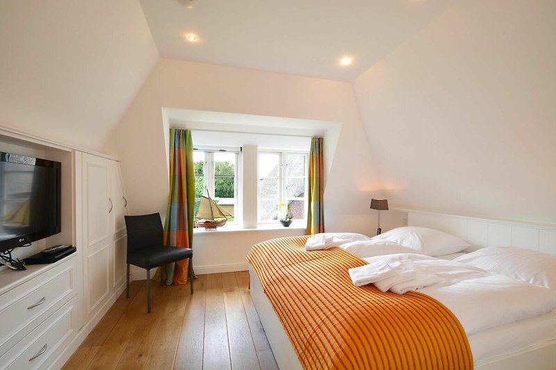 Das erste Schlafzimmer im Obergeschoss ist mit einem luxuriösen Doppelbett ausgestattet.