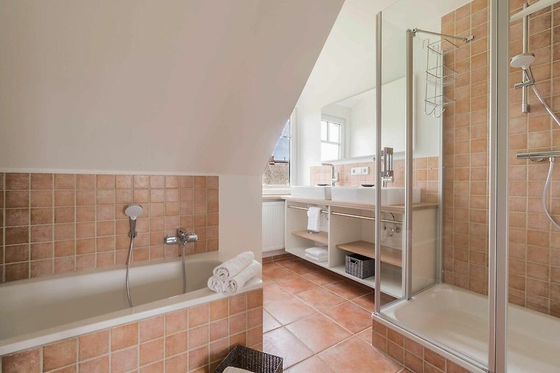 Dieses Badezimmer ist mit einer Dusche und einer Badewanne ausgestattet.