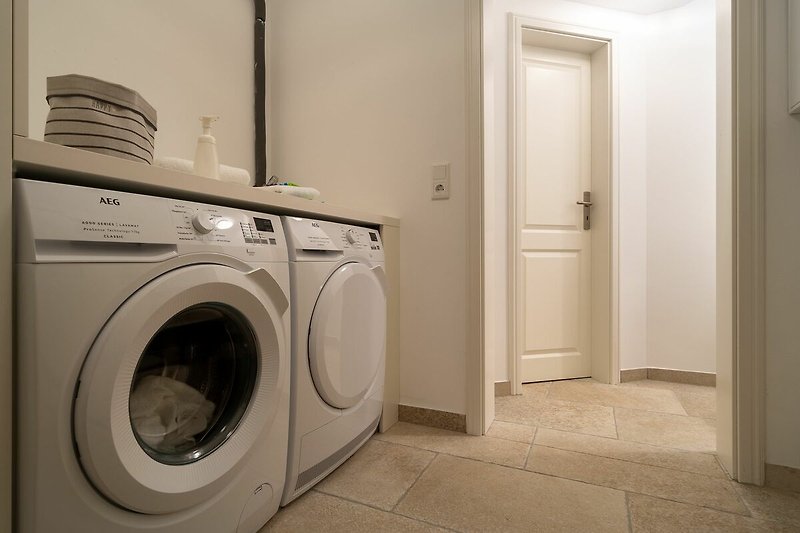 Im Hauswirtschaftsraum befinden sich Waschmaschine und Trockner für ein rundum sauberes Gefühl.