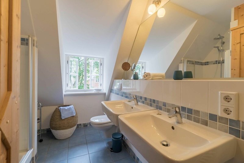 Das Duschbad im Obergeschoss ist mit Doppelwaschbecken, Dusche und einer Infrarot-Wärmekabine ausgestattet.