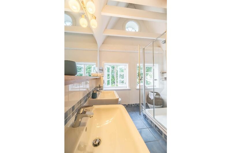 Das Duschbad im Obergeschoss ist mit Doppelwaschbecken, Dusche und Infrarot-Wärmekabine ausgestattet.
