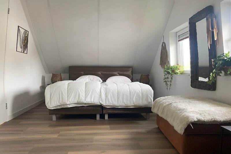 1 slaapkamer met een tweepersoonsbed, ladekast en kledingrek.