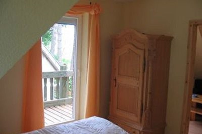 Gemütliches Schlafzimmer  mit komfortabler Einrichtung und Blick auf den Balkon.