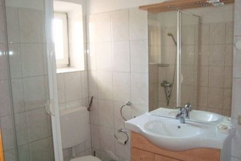 Badezimmer mit Spüle, Dusche ,Toilette und Spiegel im EG