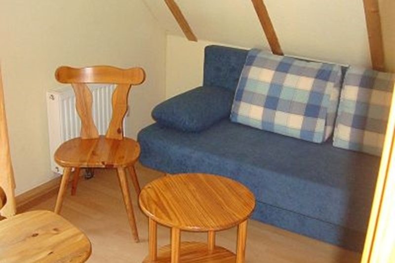 Gemütliches Studio mit bequemer Couch, Holzmöbeln und stilvollem Design (Spielzimmer)