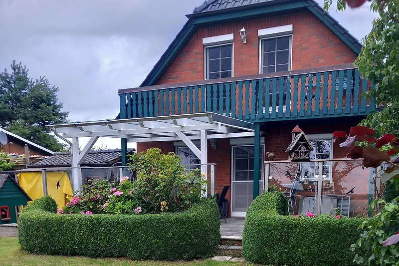 Gepflegter Garten mit einladender Terrasse und üppigen Pflanzen.