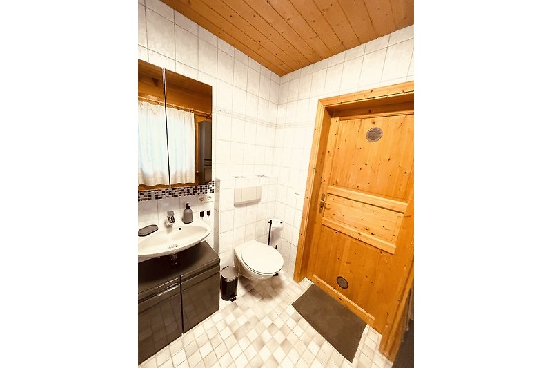 Ein stilvolles Badezimmer mit Holzmöbeln und modernen Armaturen.