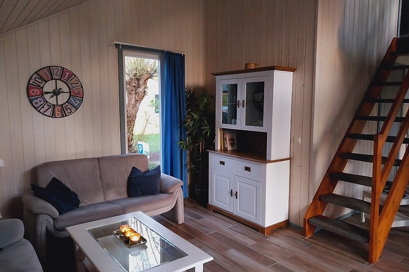 Wohnzimmer mit Holzmöbeln, Couch, Tisch und Blick auf Kamin