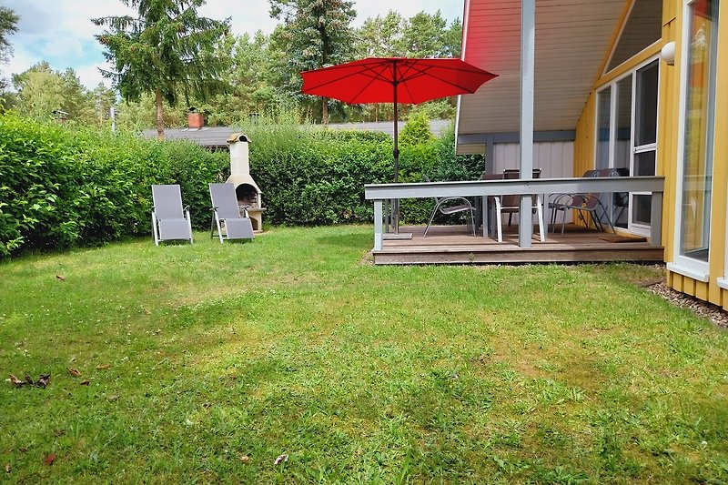Gartenidylle mit Sonnenschirm und Outdoor-Möbeln.