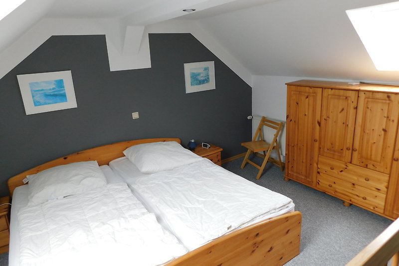 Gemütliches Schlafzimmer mit Holzmöbeln und Bett. Schlafzimmer oben