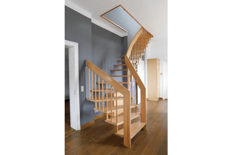 Moderne Holztreppe mit elegantem Geländer, zum oberen Schlafzimmer