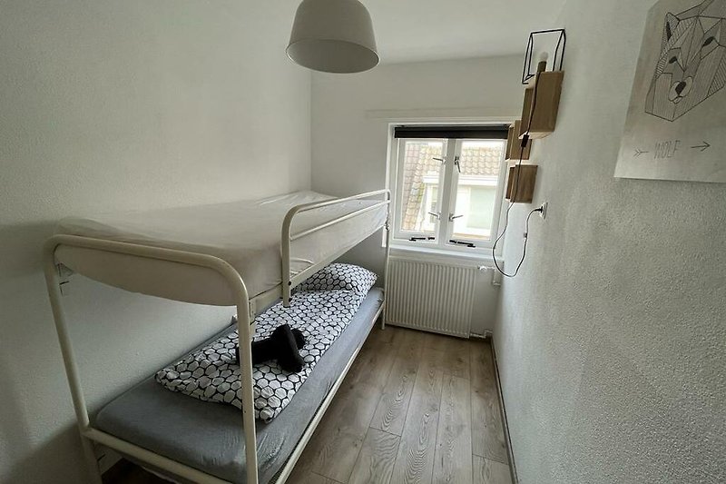 Gemütliches Schlafzimmer mit stilvoller Beleuchtung und Holzmöbeln.