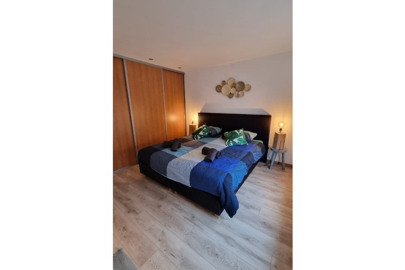 Gemütliches Schlafzimmer mit bequemem Bett, stilvoller Beleuchtung und Holzmöbeln.
