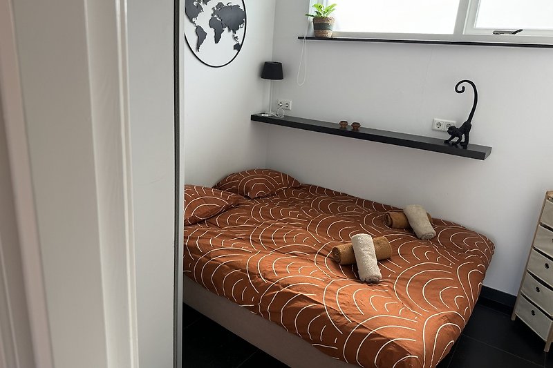 Stilvolles Schlafzimmer mit Holzbett und gemütlicher Bettwäsche.