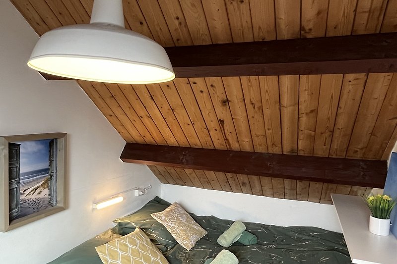Gemütliches Wohnzimmer mit Holzboden und stilvoller Beleuchtung.