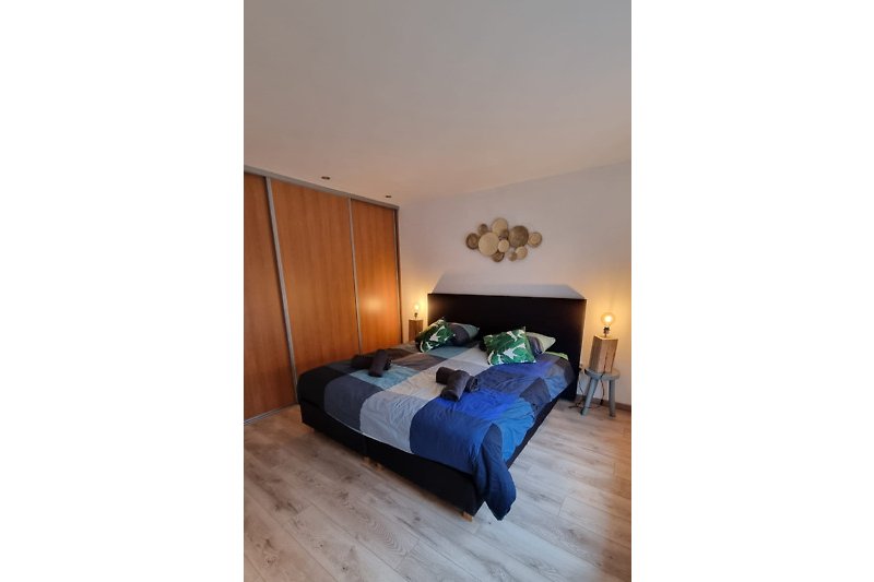 Gemütliches Schlafzimmer mit Holzmöbeln, bequemem Bett und stilvoller Beleuchtung.