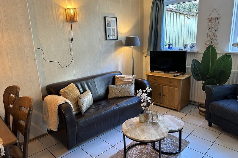 Stilvolles Wohnzimmer mit bequemer Couch, Tisch und Pflanze.
