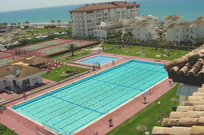 Hermosa piscina con vista urbana y área de recreación. ¡Vacaciones perfectas en este resort!