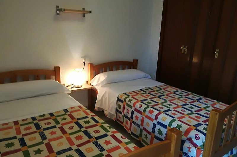 Habitación acogedora con muebles de madera y ropa de cama cómoda.