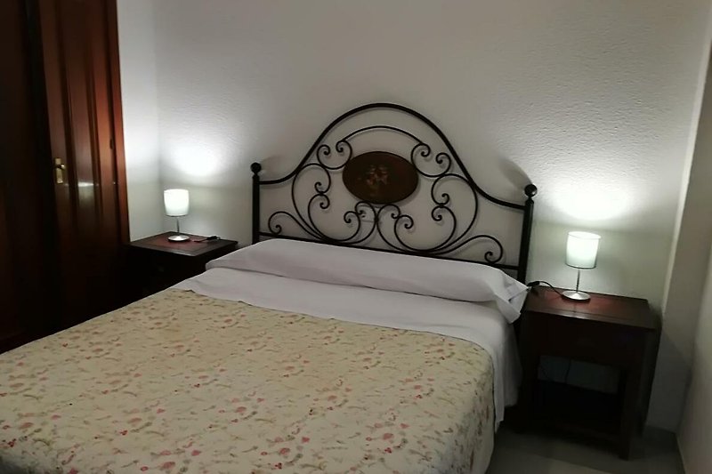 Habitación con cómoda cama de madera y elegante decoración.