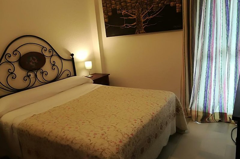 Hermosa habitación con cómoda cama de madera y elegante decoración.