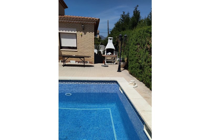 Schwimmbad mit Sonnenliegen und Sonnenschirmen in einer Ferienanlage. Erholung am Pool.