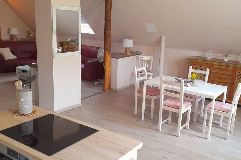 Moderne Wohnung mit Holzmöbeln, Tisch, Stühlen und Küche.
