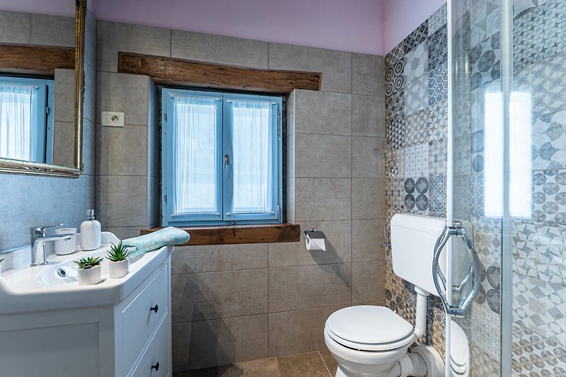 Prekrasna kupaonica s drvenim ormarićem, umivaonikom i ogledalom.