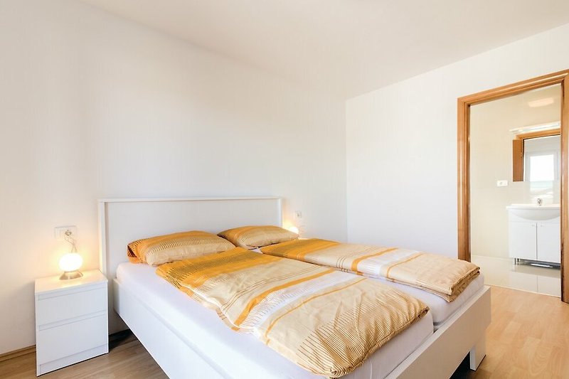 Udobna spavaća soba s drvenim namještajem i udobnim krevetom.