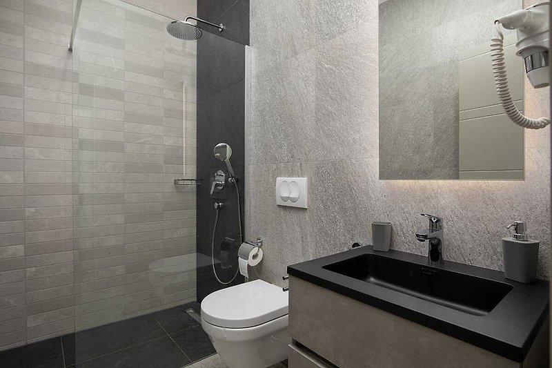 Elegantna kupaonica s modernim namještajem i crnim detaljima.