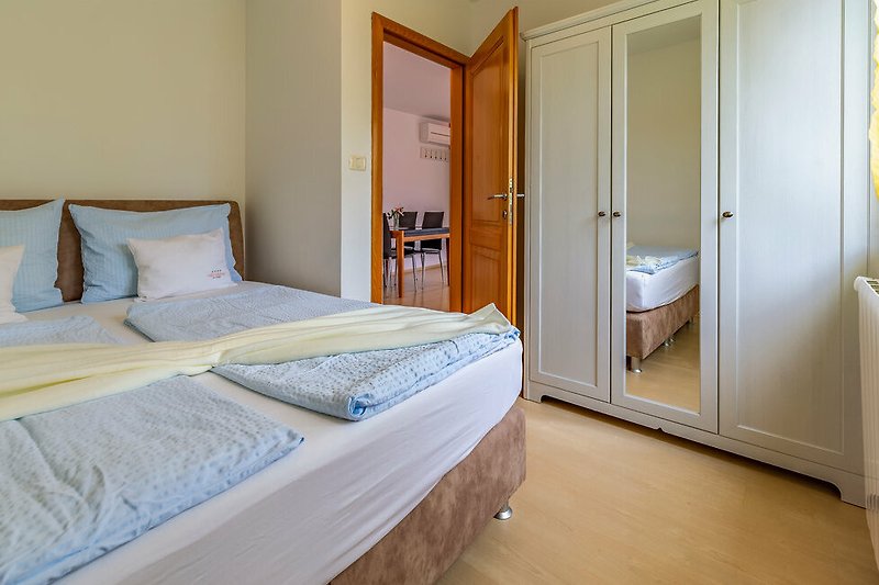Predivan interijer spavaće sobe s udobnim krevetom i drvenim namještajem.