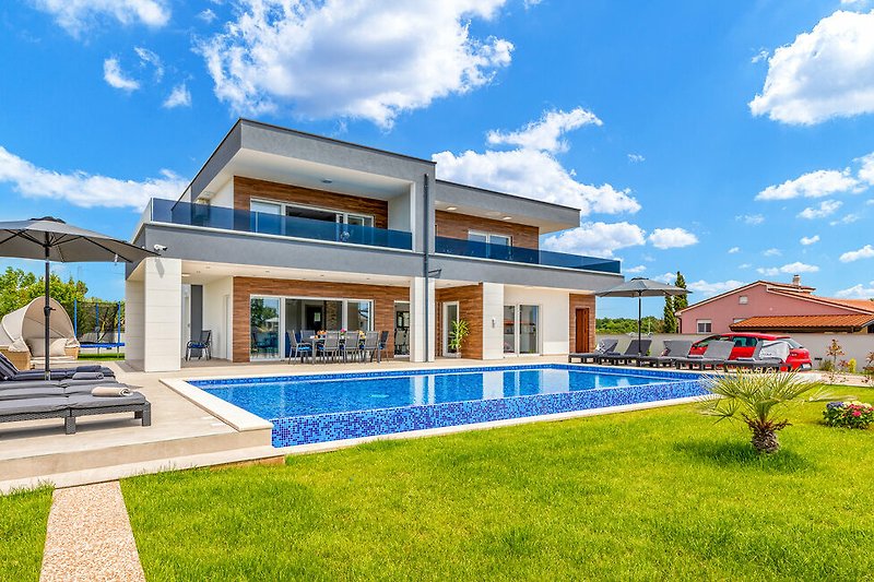 Una vista meravigliosa di una casa con piscina, circondata da verde e alberi.