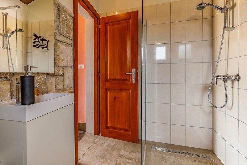 Predivna kuća s lijepim drvenim vratima i modernom kupaonicom.