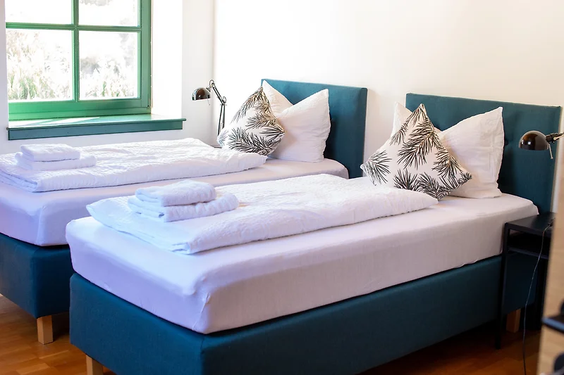 Komfortables Doppelbett mit frischer Bettwäsche und dekorativem Kissen.