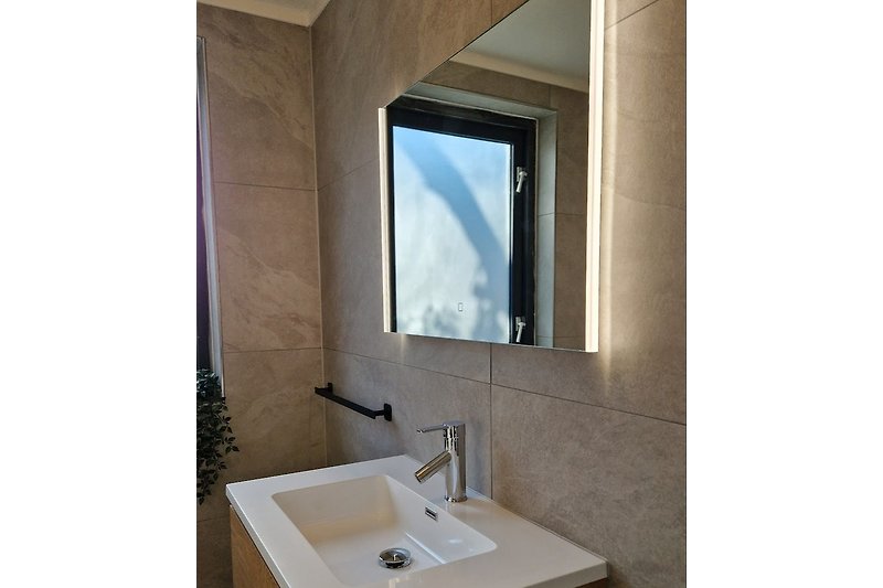 Nieuwe badkamer met verwarmde spiegel