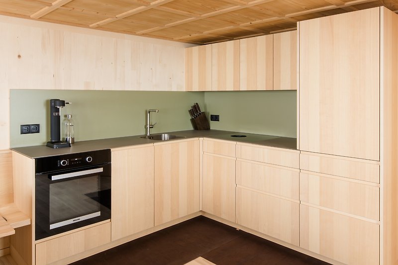 Moderne Küche mit Holzboden und Granit-Arbeitsplatte. Edle Armaturen und hochwertige Schränke.