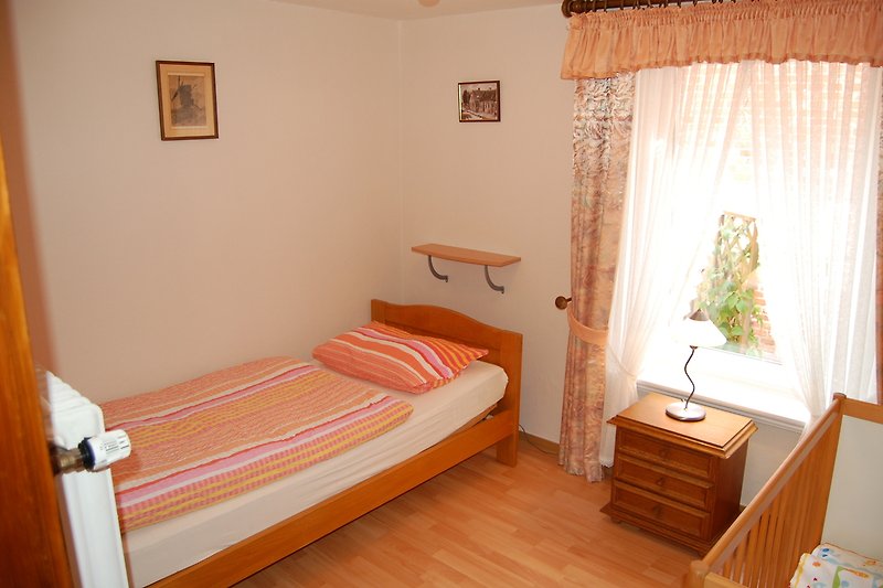 Schlafzimmer mit Einzelbett und Kinderbett