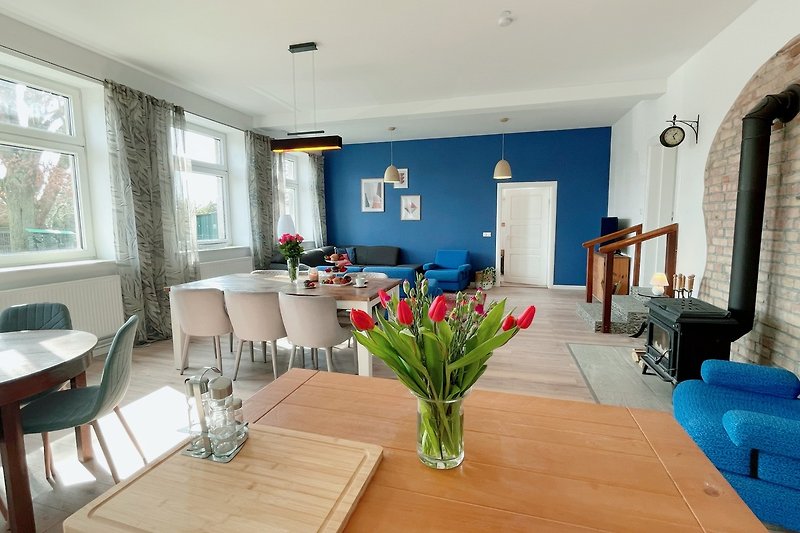 Schönes Wohnzimmer mit Holzmöbeln, blauen Akzenten und Pflanzen. Perfekt zum Entspannen und Essen.