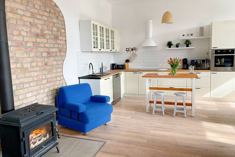 Gemütliches Wohnzimmer mit moderner Einrichtung und Holzboden. Entspannen Sie auf dem Sofa oder genießen Sie eine Mahlzeit am Esstisch.