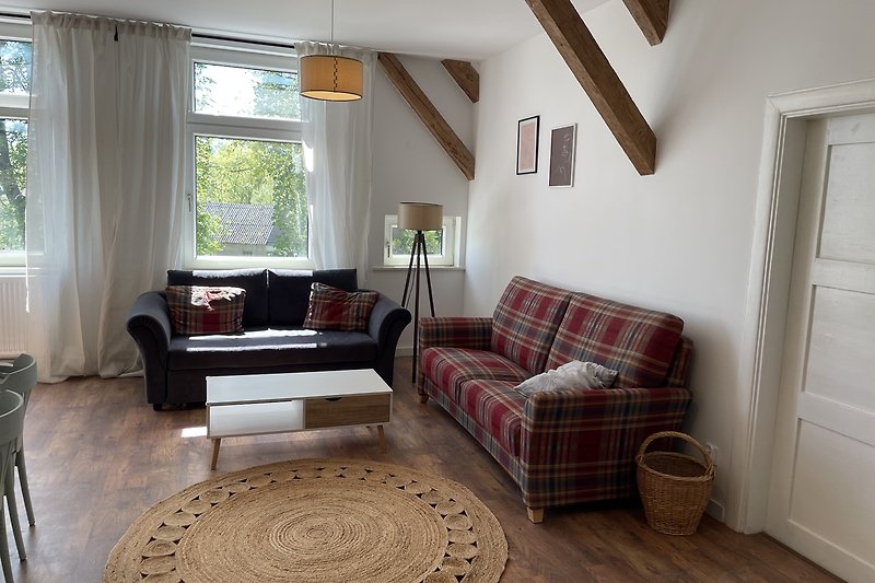 Gemütliches Wohnzimmer mit bequemer Couch und großem Fenster. Perfekt zum Entspannen und Genießen der Aussicht.