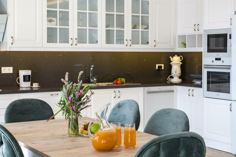 Moderne Küche mit Holzmöbeln, Pflanzen und Gasofen. Gemütliche Atmosphäre.