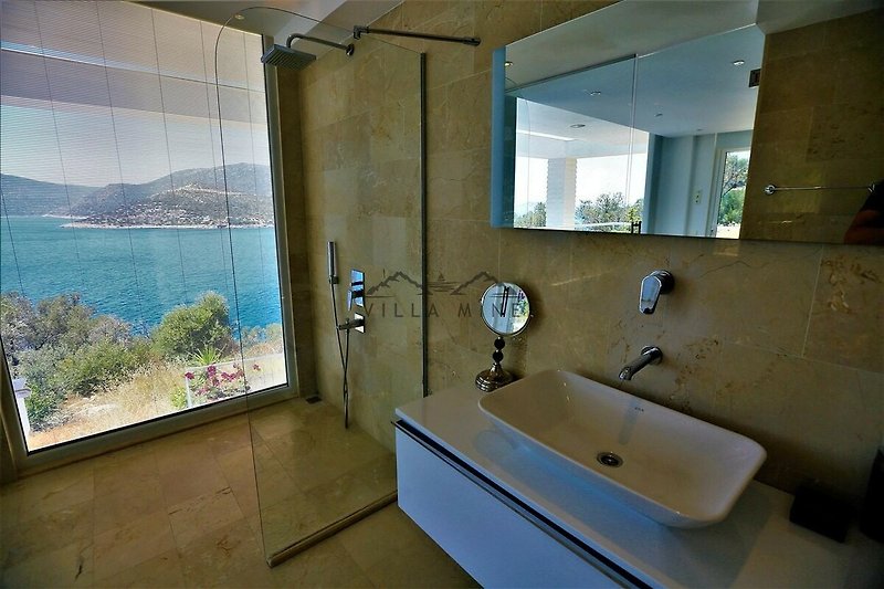 Badezimmer mit Spiegel, Badewanne und Pflanze.