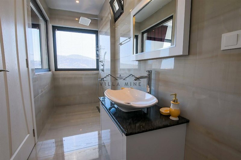 Modernes Badezimmer mit elegantem Spiegel und Marmorwaschbecken.