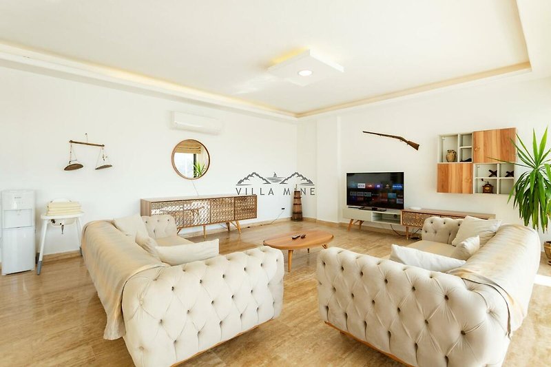 Wohnzimmer mit bequemer Couch, Fernseher, Holzmöbeln und stilvoller Beleuchtung.